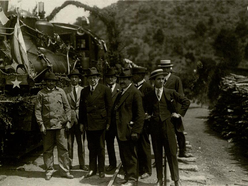 Cauquenes, 1920. Positivo en papel. 8.9 x 12 cm. Colección Fotográfica, n.° inventario 98.486.
«El señor Alessandri a la llegada a la estación Baños de Cauquenes, con el maquinista que condujo el convoy y un grupo de la comitiva». Sucesos, 944, 28 de oct